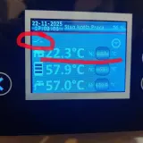 Wyświetlacz kotła z datą 22-11-2025, godziną 17:02:03, stanem "Praca 76%", temperaturą 22.3°C, 57.9°C i 57.0°C. Widoczny symbol technix argos pid plus.