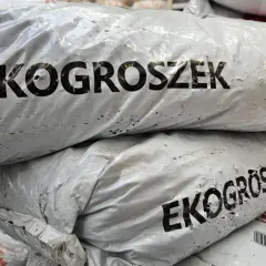 Stos worków z ekogroszkiem, gotowych do ogrzania domu.