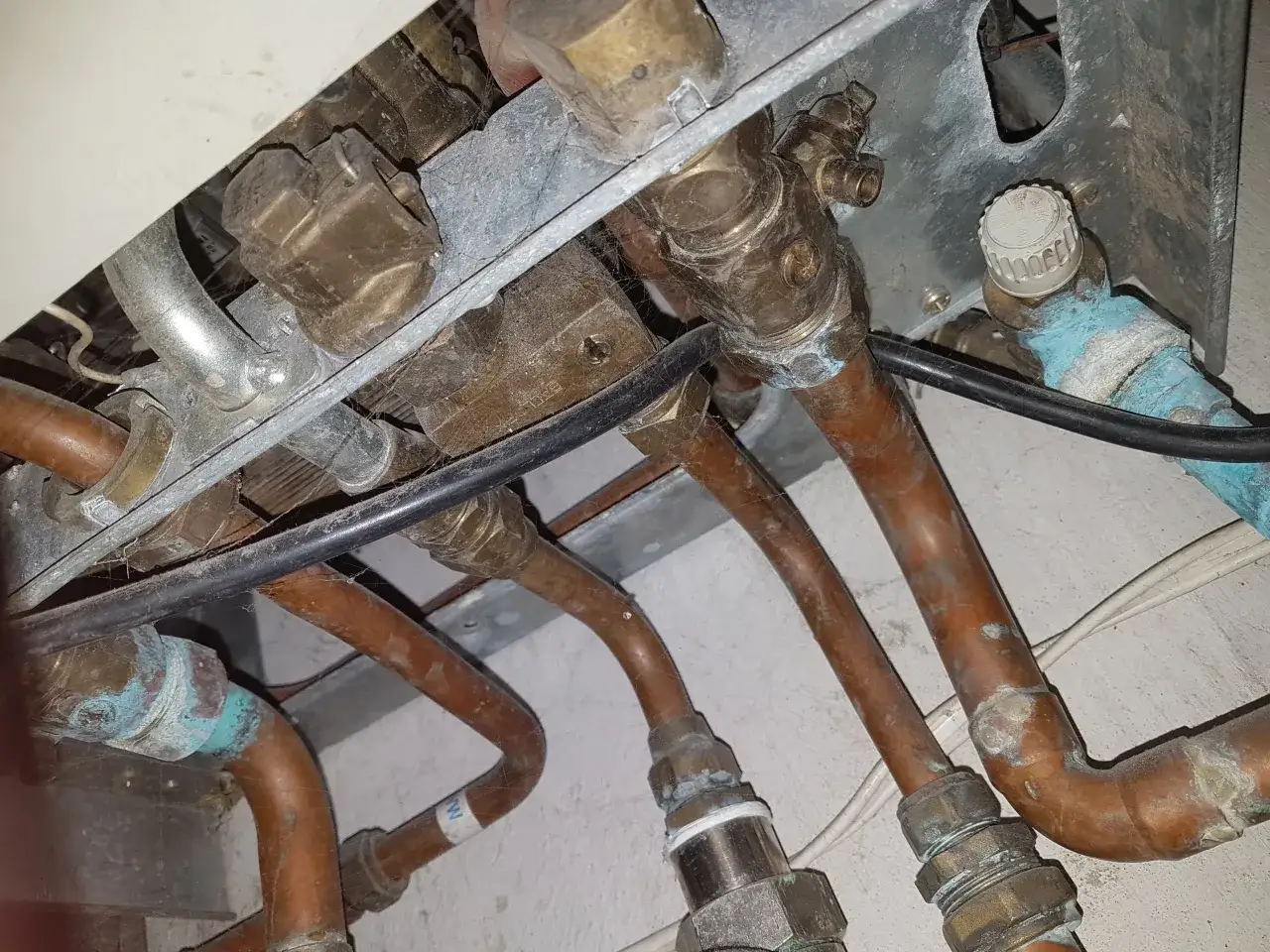Instalacja pieca gazowego Vaillant z miedzianymi rurami. Widoczne przyłącza i zawory, potencjalnie związane ze słabym ciśnieniem ciepłej wody.