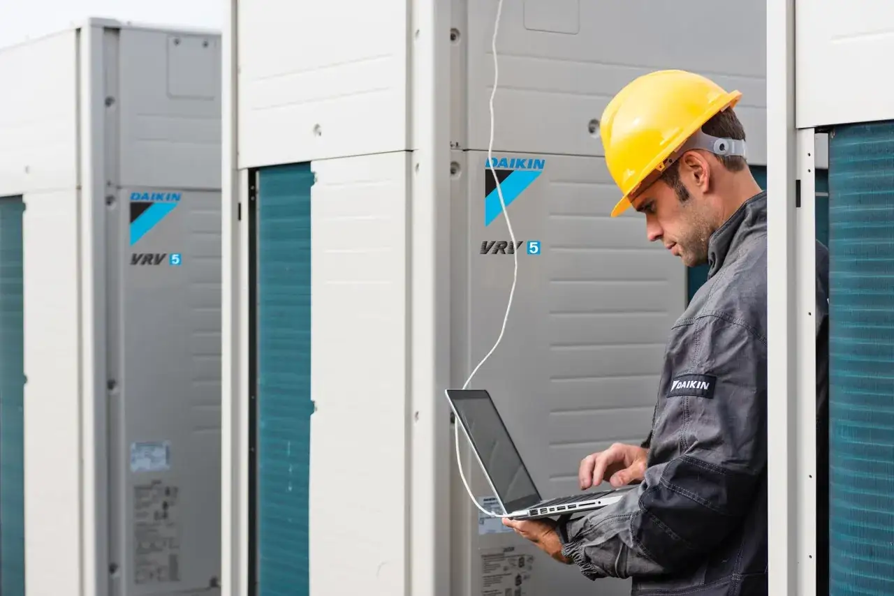 Technik w żółtym kasku sprawdza system VRV 5. Profesjonalny serwis Daikin Warszawa.